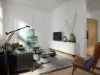 Ein stilvoll eingerichtetes Wohnzimmer mit modernen Möbeln und einem Fernseher auf einem Sideboard. Nolte Living.