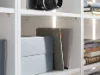 Ein weißes Regal mit Büchern und Boxen, Teil der Nolte Living Kollektion.