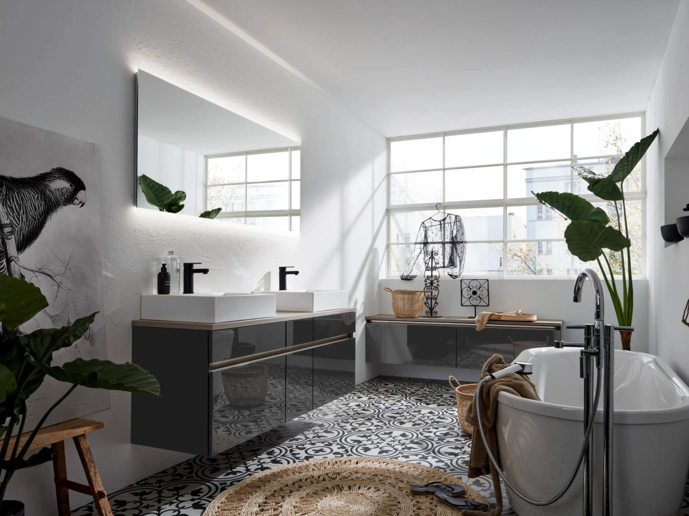 Ein modernes Badezimmer mit Badewanne und Doppelwaschbecken, umgeben von Pflanzen. Nolte SPA.