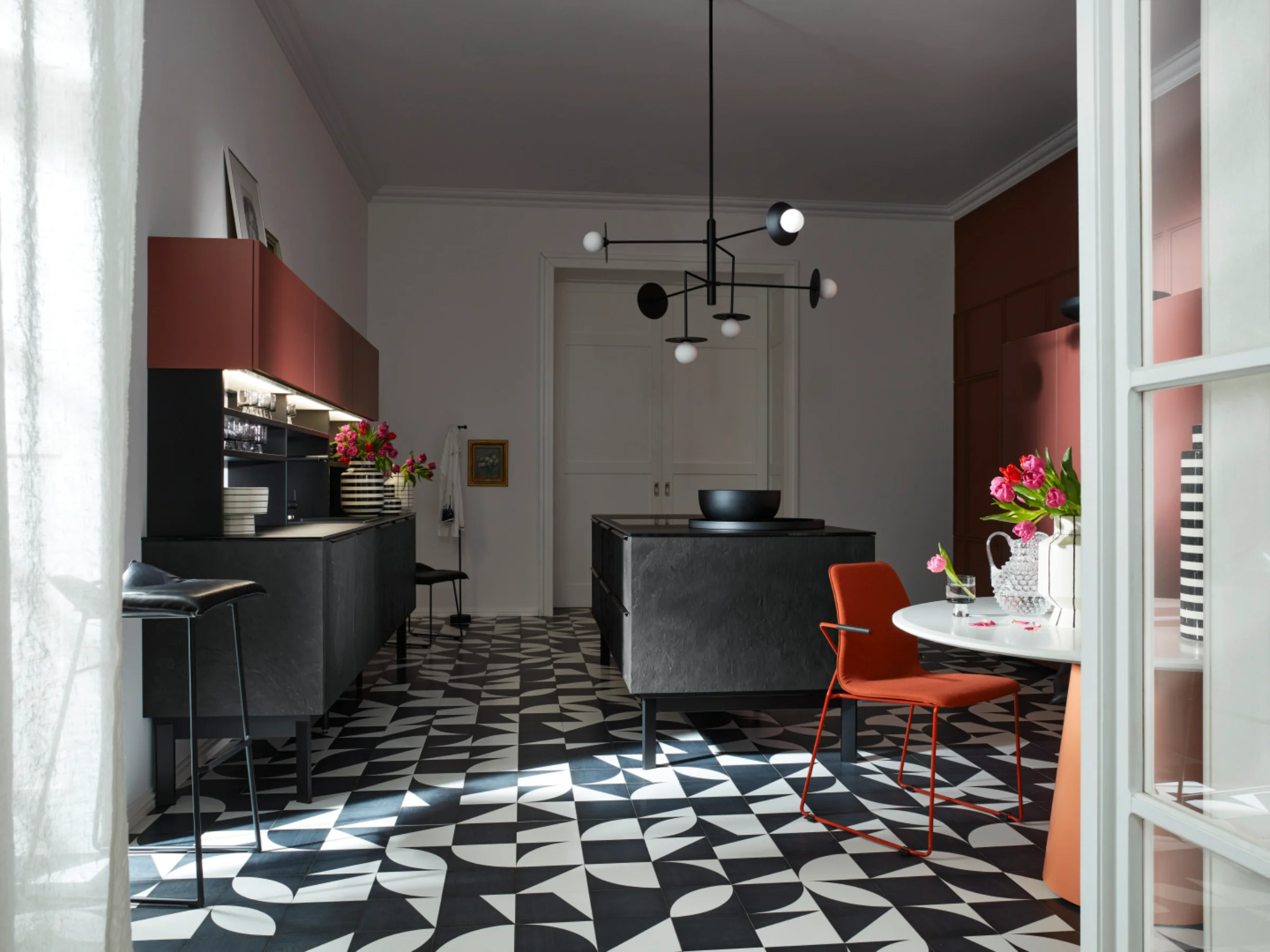 Eine moderne Küche mit geometrischem Boden und stilvollen Möbeln, gestaltet von Nolte Küchen.