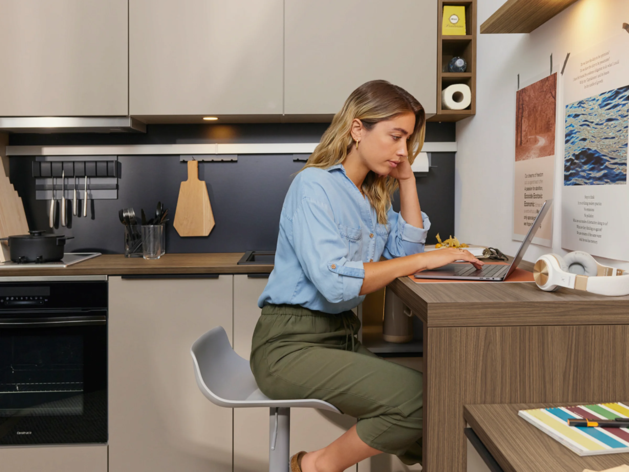 Eine Frau arbeitet in einer modernen Küche mit Nolte Küchen am Laptop.