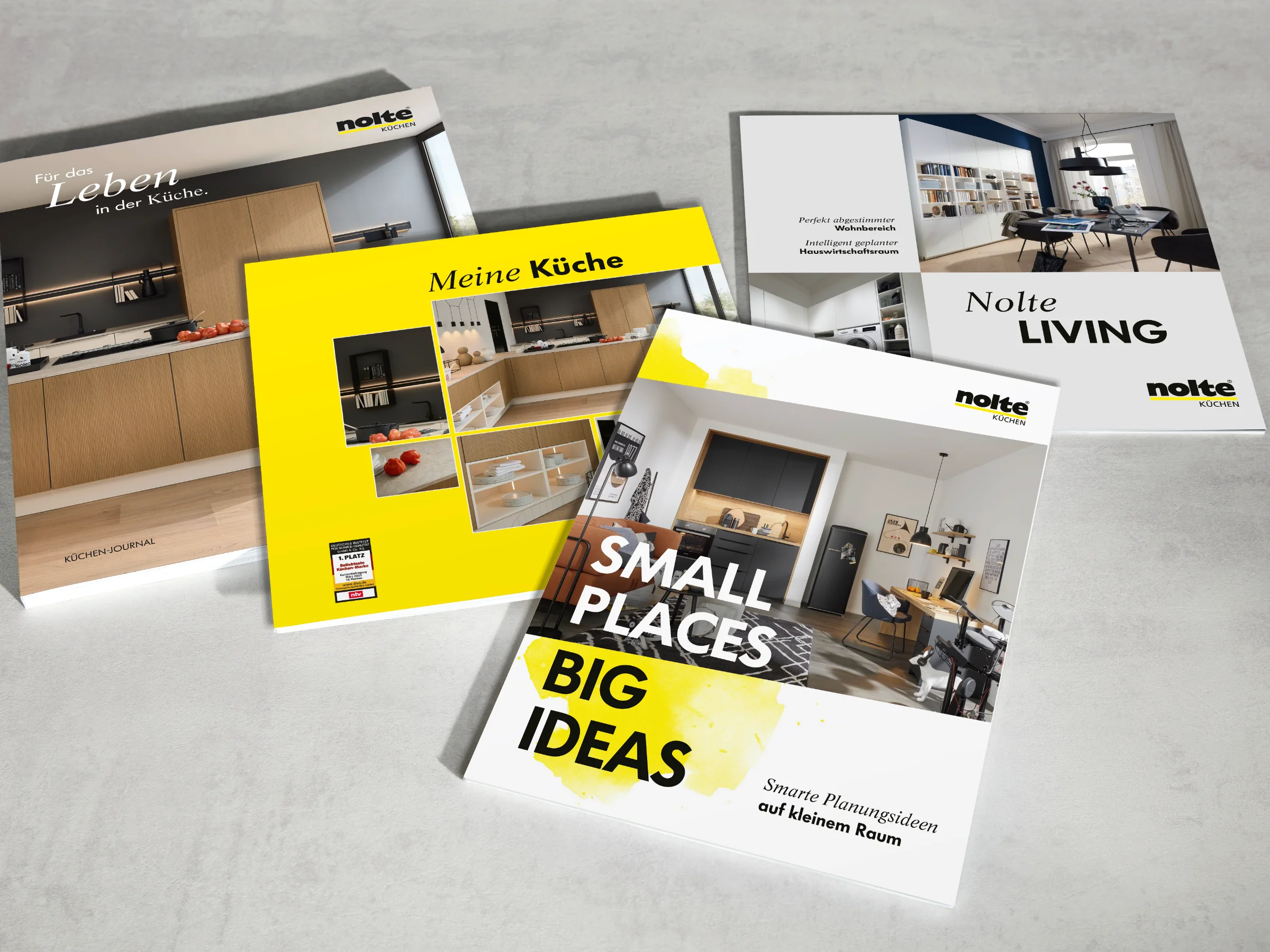 Vier Broschüren über Nolte Küchen, Nolte Living und NolteNeo-Designs liegen auf einem Tisch.