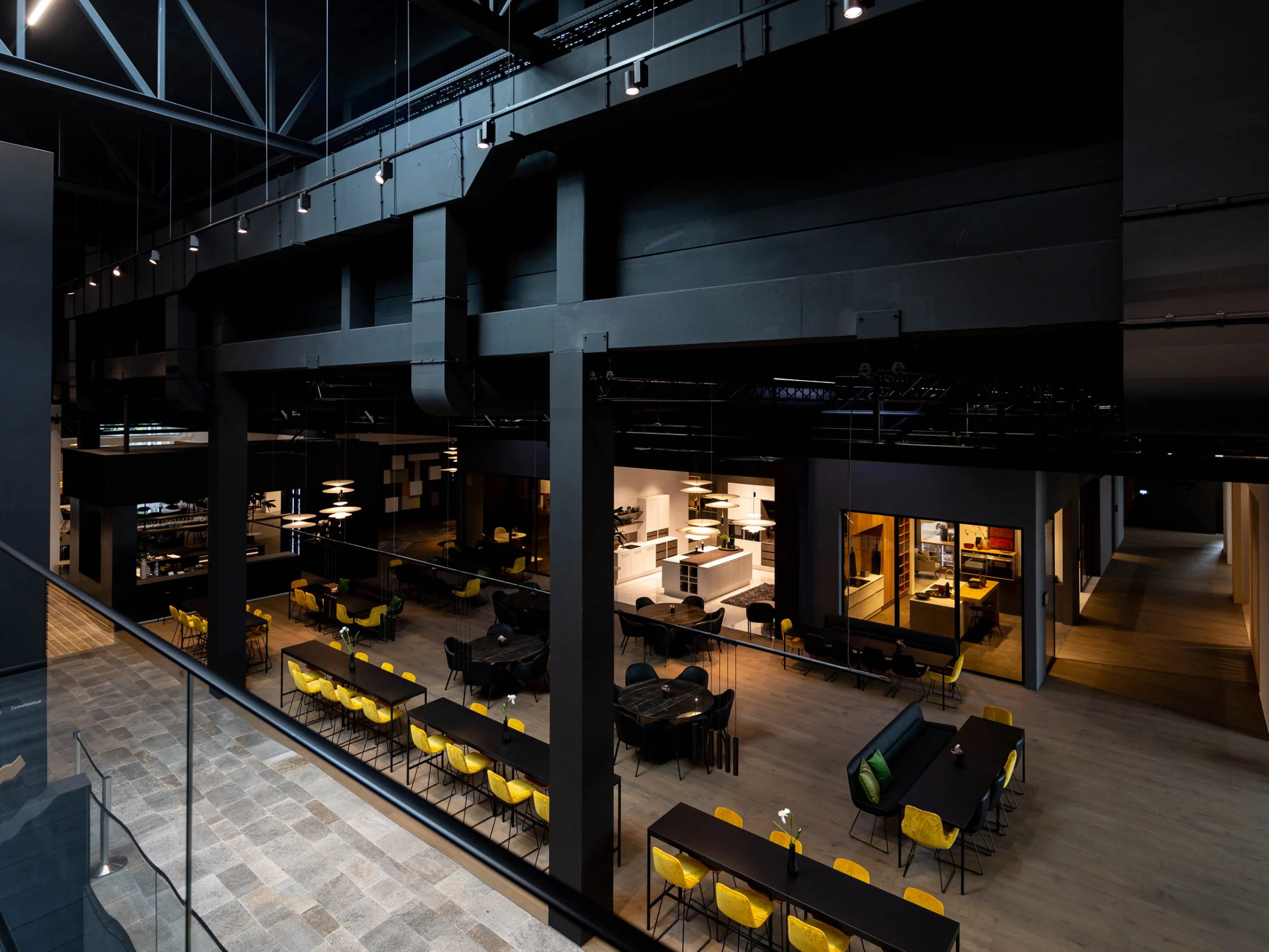 Ein großer, moderner Raum mit langen Tischen und gelben Stühlen, passend für Nolte Living.