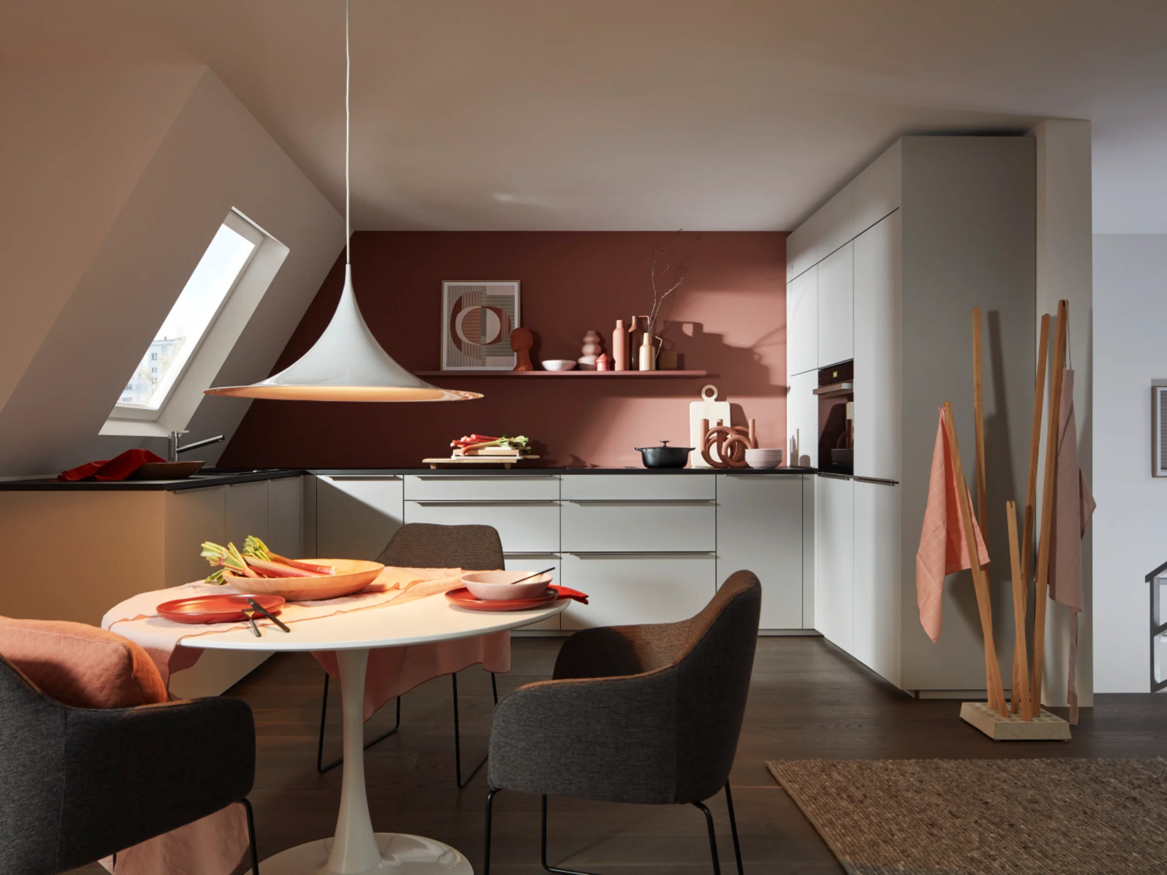 Eine moderne Küche mit Esstisch und Stühlen in eleganten Farben. Nolte Küchen.