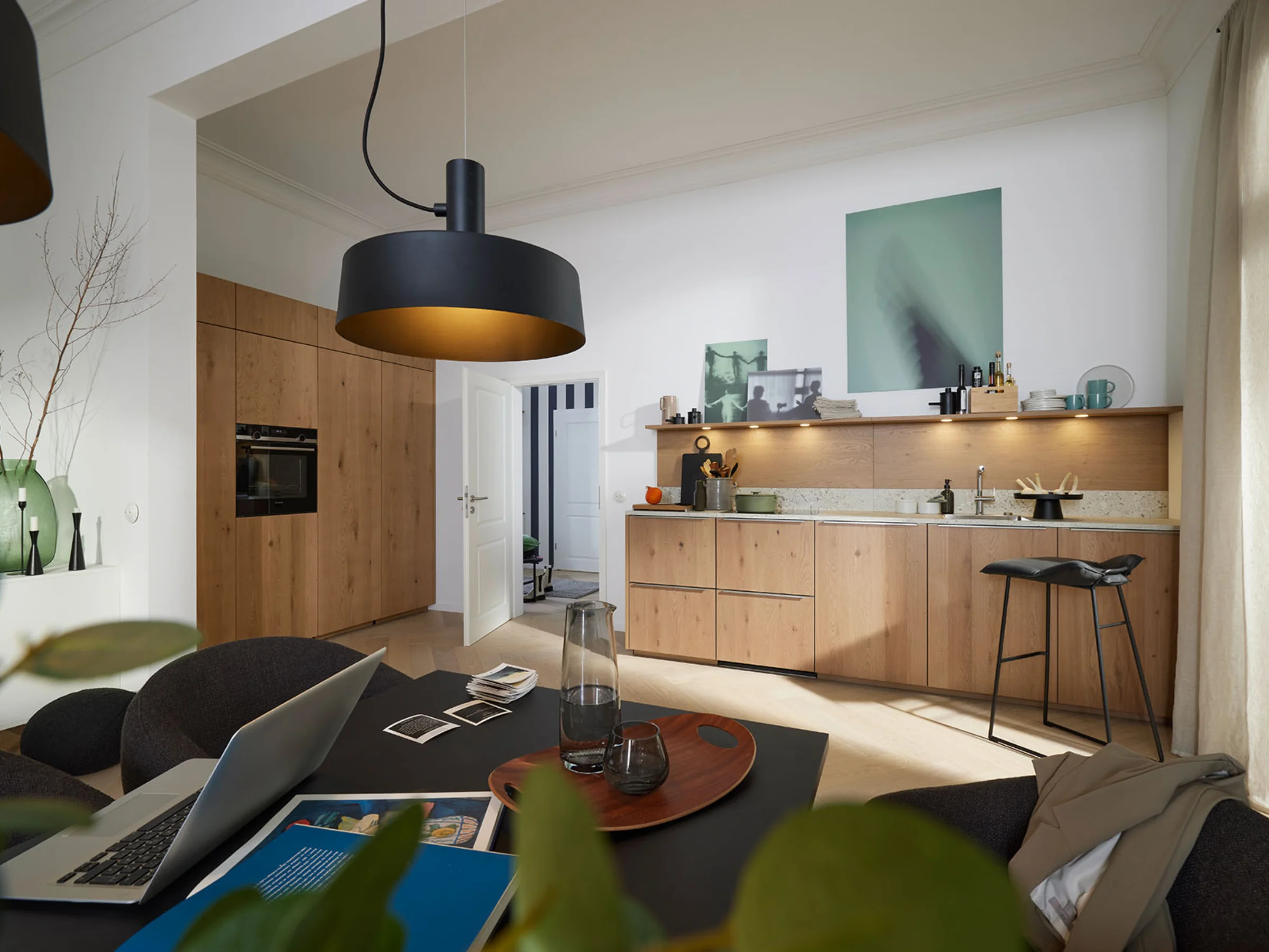 Eine moderne Küche mit Holzschränken und Kochinsel in einem offenen Raum. Nolte Küchen.