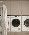 Ein Hauswirtschaftsraum mit Waschmaschine, Trockner und Schränken; Nolte Hauswirtschaftsräume.