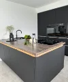 Eine moderne Küche mit dunklen Schränken und Holzakzenten, ausgestattet von Nolte Küchen.