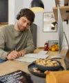Ein Mann arbeitet an einem Schreibtisch in einer modernen Küche von Nolte Küchen.