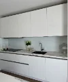 Eine moderne, weiße Küche mit Marmorarbeitsplatte und Spüle. Nolte Küchen.