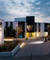The modern Nolte Forum building at dusk, surrounded by lit pathways and green spaces.