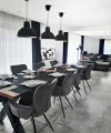 Ein stilvoll eingerichtetes Esszimmer mit langer Tafel und modernen Leuchten von Nolte Living.