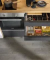 In einer modernen Küche sind offene Schubladen mit Besteck und Utensilien zu sehen, Nolte Küchen.