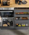 Eine moderne Küche mit geöffneten Schubladen und Utensilien von Nolte Küchen.