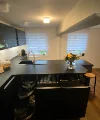 Een moderne keuken met donkere kasten en een kookeiland, ingericht door Nolte Kitchen.