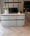Eine moderne Küche mit Insel und Blumenvasen, gestaltet von Nolte Küchen.