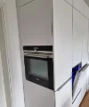 Een moderne inbouwkeuken met witte kasten en ingebouwde oven, van Nolte Kitchen.