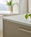 Eine moderne Küche mit Zitronen auf der Arbeitsplatte, im Hintergrund ein Sitzbereich. Nolte Küchen.