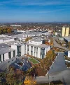 A modern building with large glass fronts surrounded by an autumn landscape. Nolte Kitchens.
