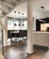 Eine moderne Nolte Küchen Einbauküche mit Essbereich und Treppe in einem offenen Wohnraum.