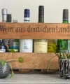 Eine Holzkiste mit Flaschen und Pflanzen vermittelt ein stilvolles Ambiente, passend zu Nolte Küchen.
