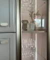 A glass display cabinet with wine glasses and decor in a kitchen, Nolte Kitchen.