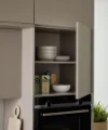 In einer modernen Küche mit offenen Schränken präsentiert sich Nolte Küchen.