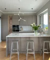 A modern kitchen with gray cabinets and an island, decorated with flowers. Nolte Kitchens.