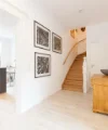 Ein heller Flur mit Treppe und Blick in eine moderne Küche von Nolte Küchen.