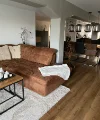 Ein modernes Wohnzimmer mit braunem Sofa und Esstischbereich; Nolte Living.