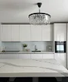 Eine moderne Küche mit weißem Interieur und Kronleuchter, gestaltet von Nolte Küchen.