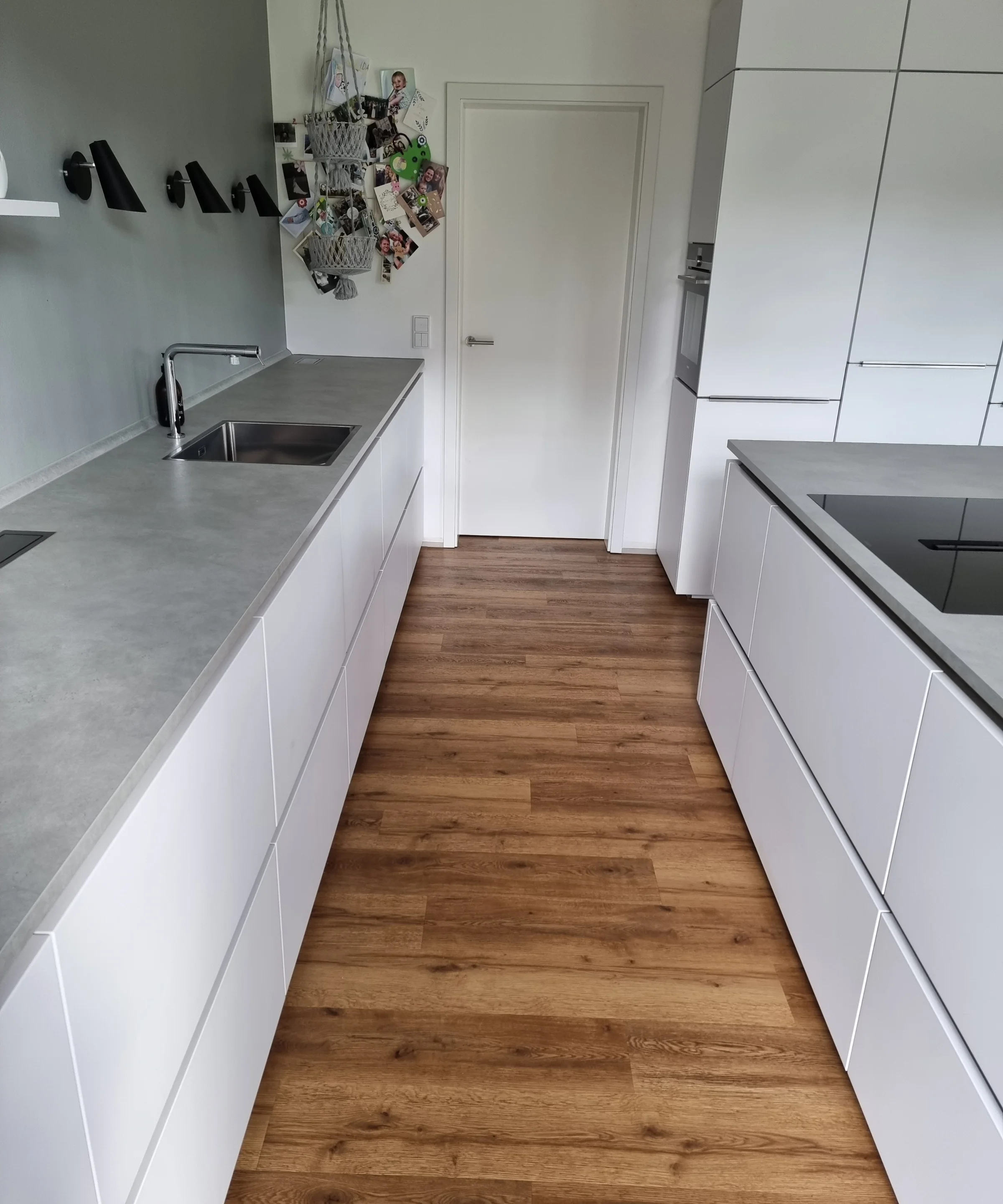 Cuisine moderne avec armoires blanches et sol en bois, Nolte Kitchen.