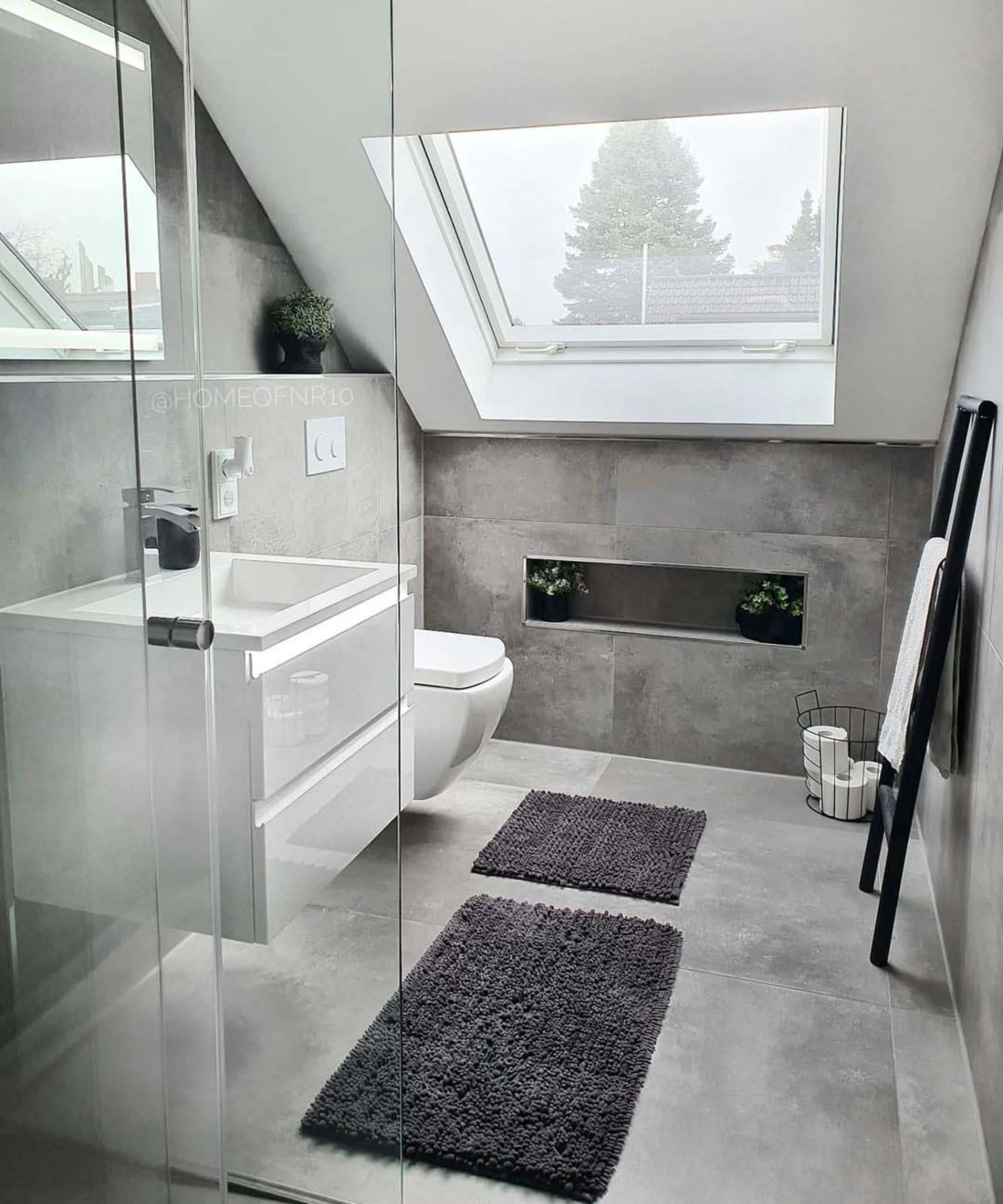 Modernes Badezimmer mit grauen Fliesen, Dachfenster und minimalistischer Einrichtung. Nolte SPA.