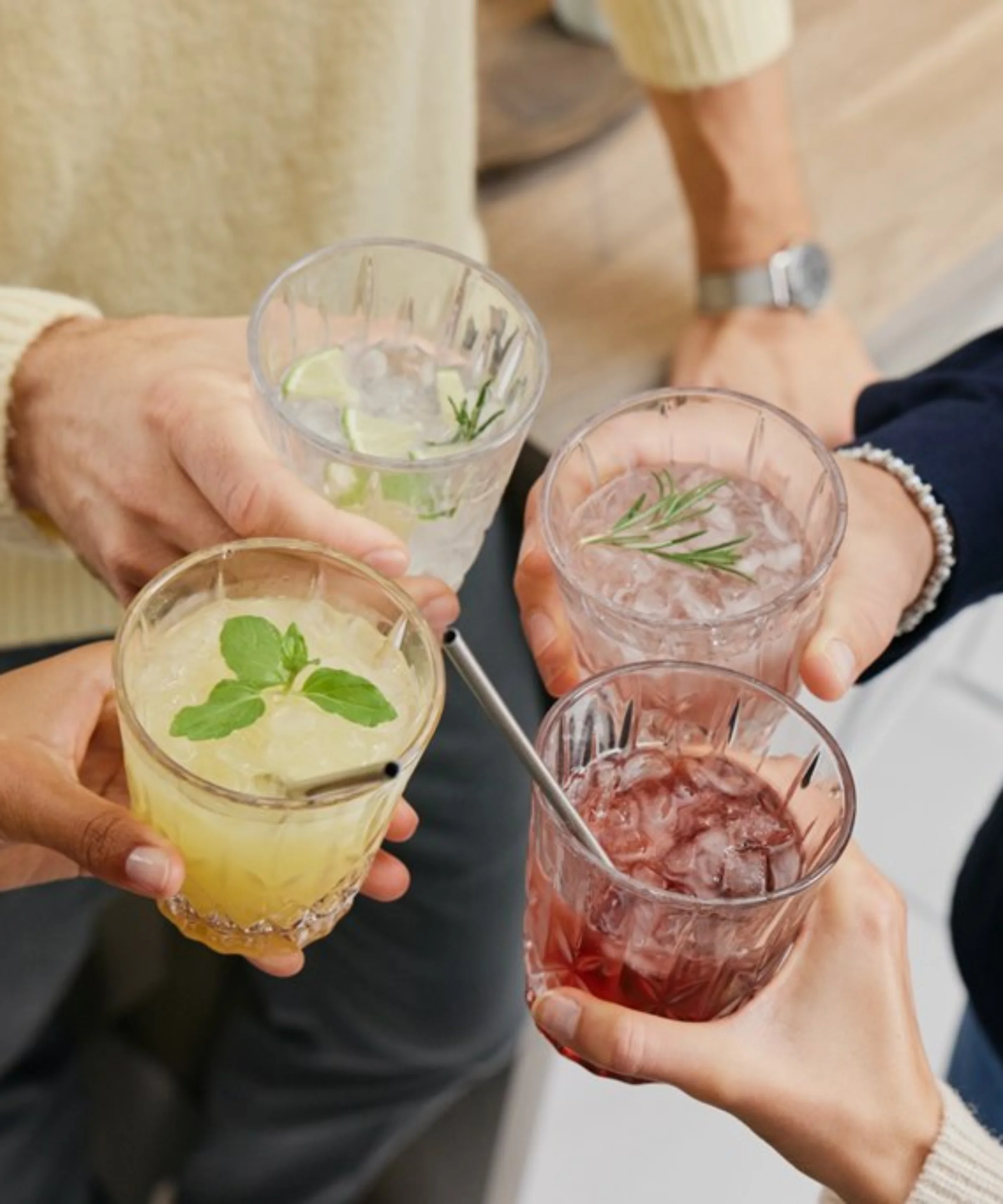 Vier Personen stoßen mit verschiedenen Cocktails an, Nolte Küchen.