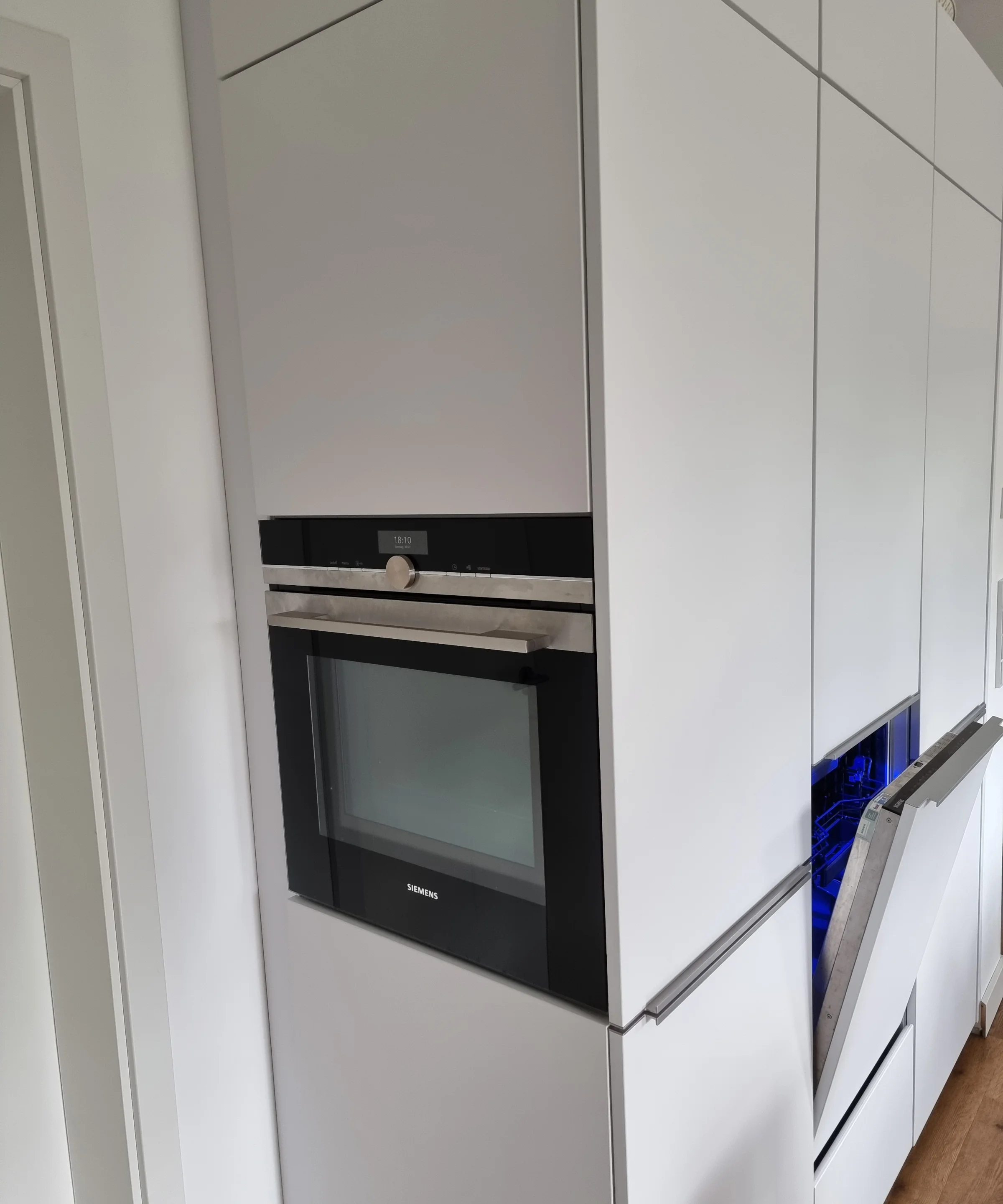 Een moderne inbouwkeuken met witte kasten en ingebouwde oven, van Nolte Kitchen.