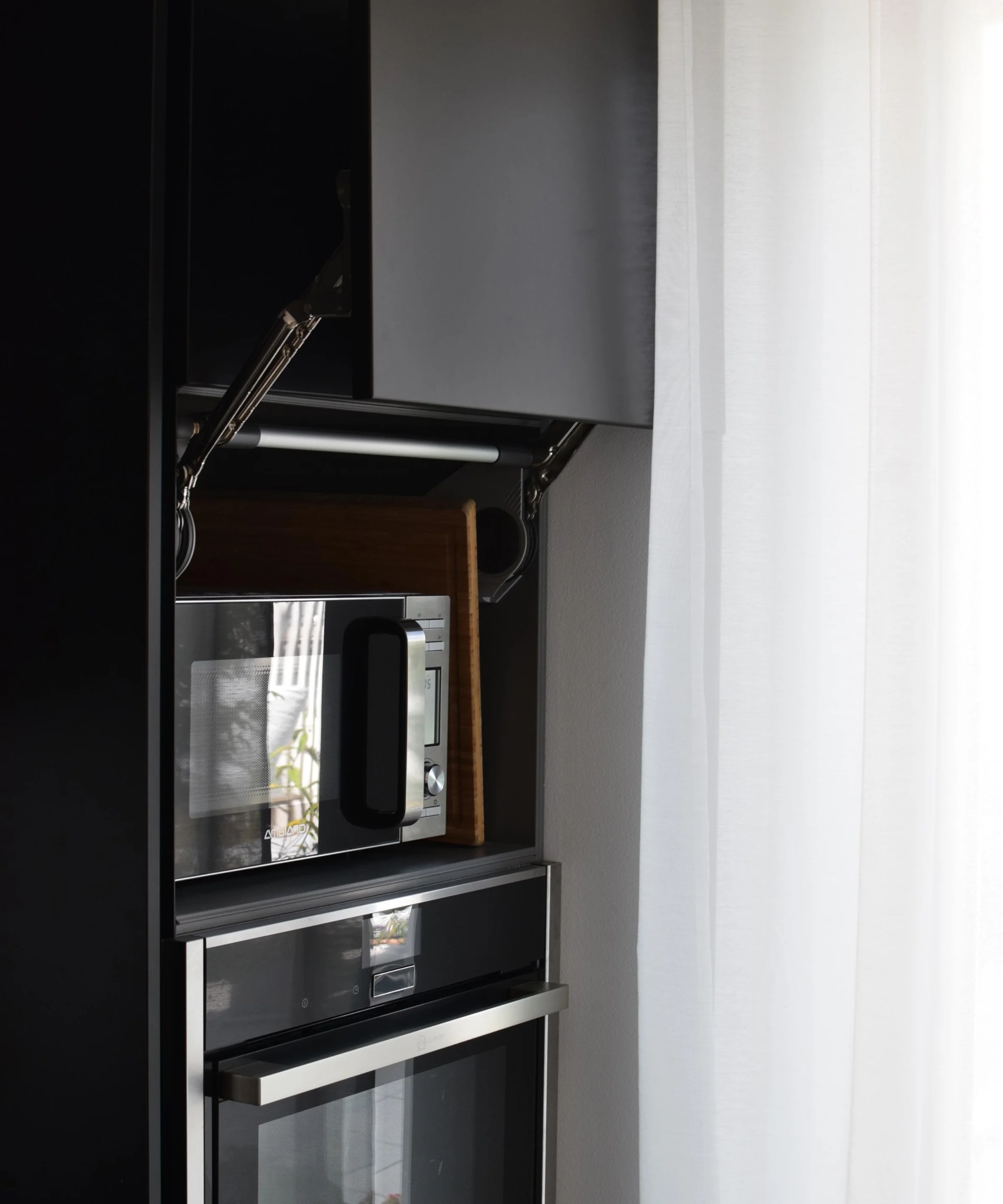Ein moderner Küchenschrank mit Ofen und Mikrowelle, elegant gestaltet von Nolte Küchen.