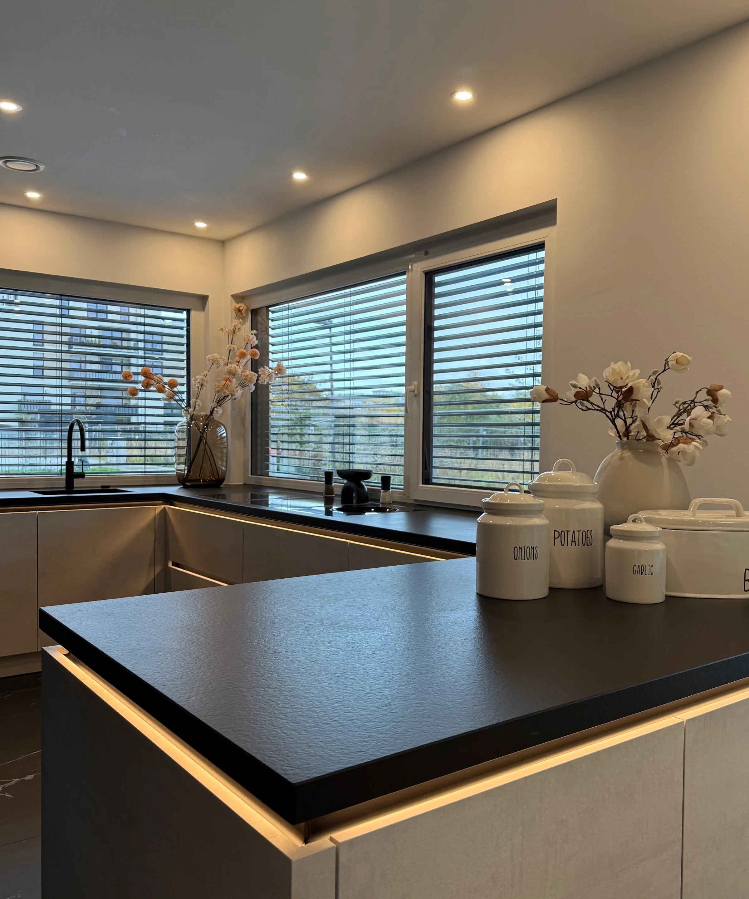 Cucina moderna con isola e grandi finestre, decorata con stile. Nolte Küchen.