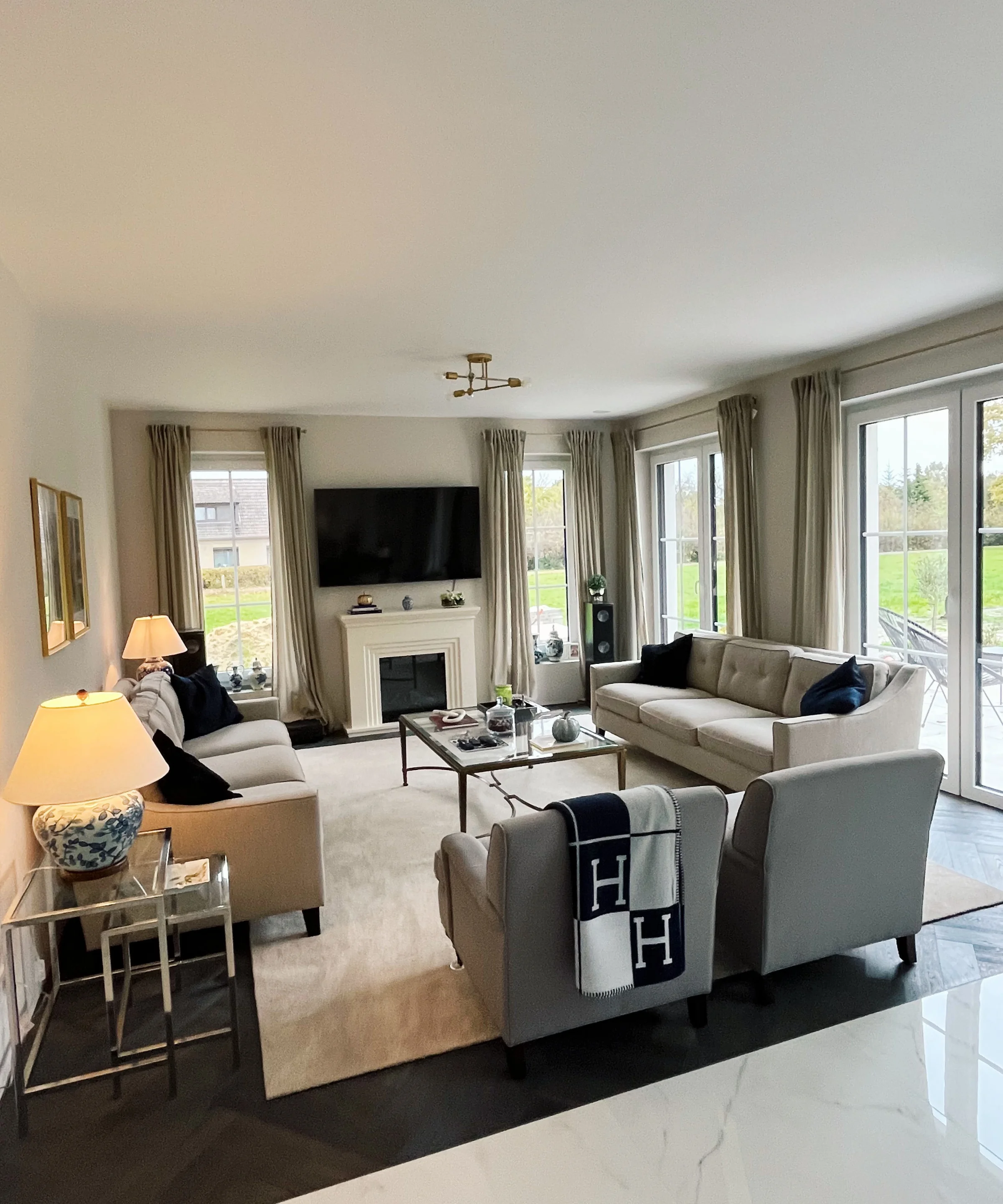 Ein Wohnzimmer mit Sofas und Sesseln, dekoriert mit Kissen und Decken, ist zu sehen. Nolte Living.