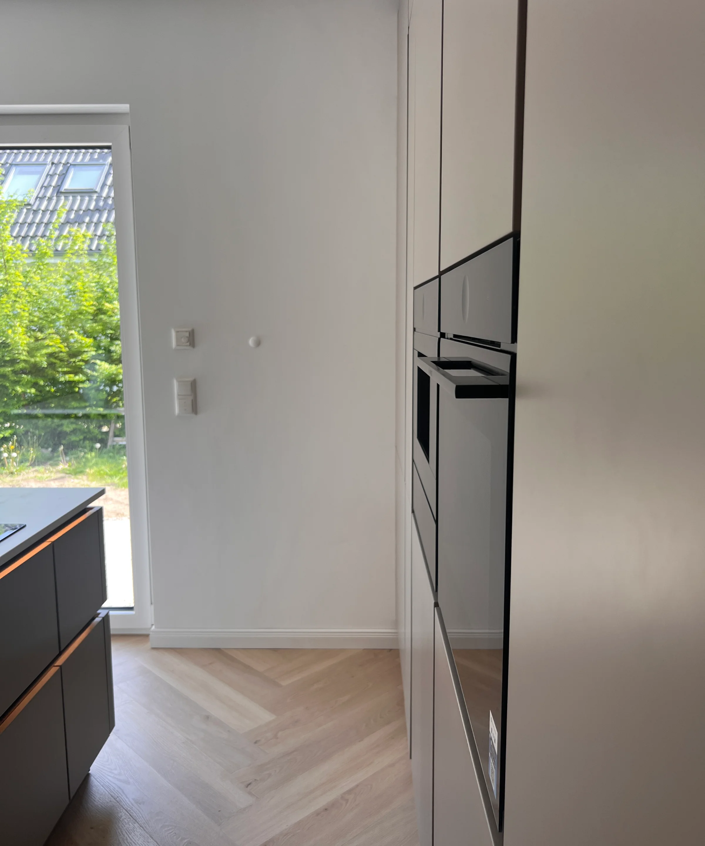 Moderne Küche mit Einbaugeräten und hellem Holzfußboden, im Design von Nolte Küchen.