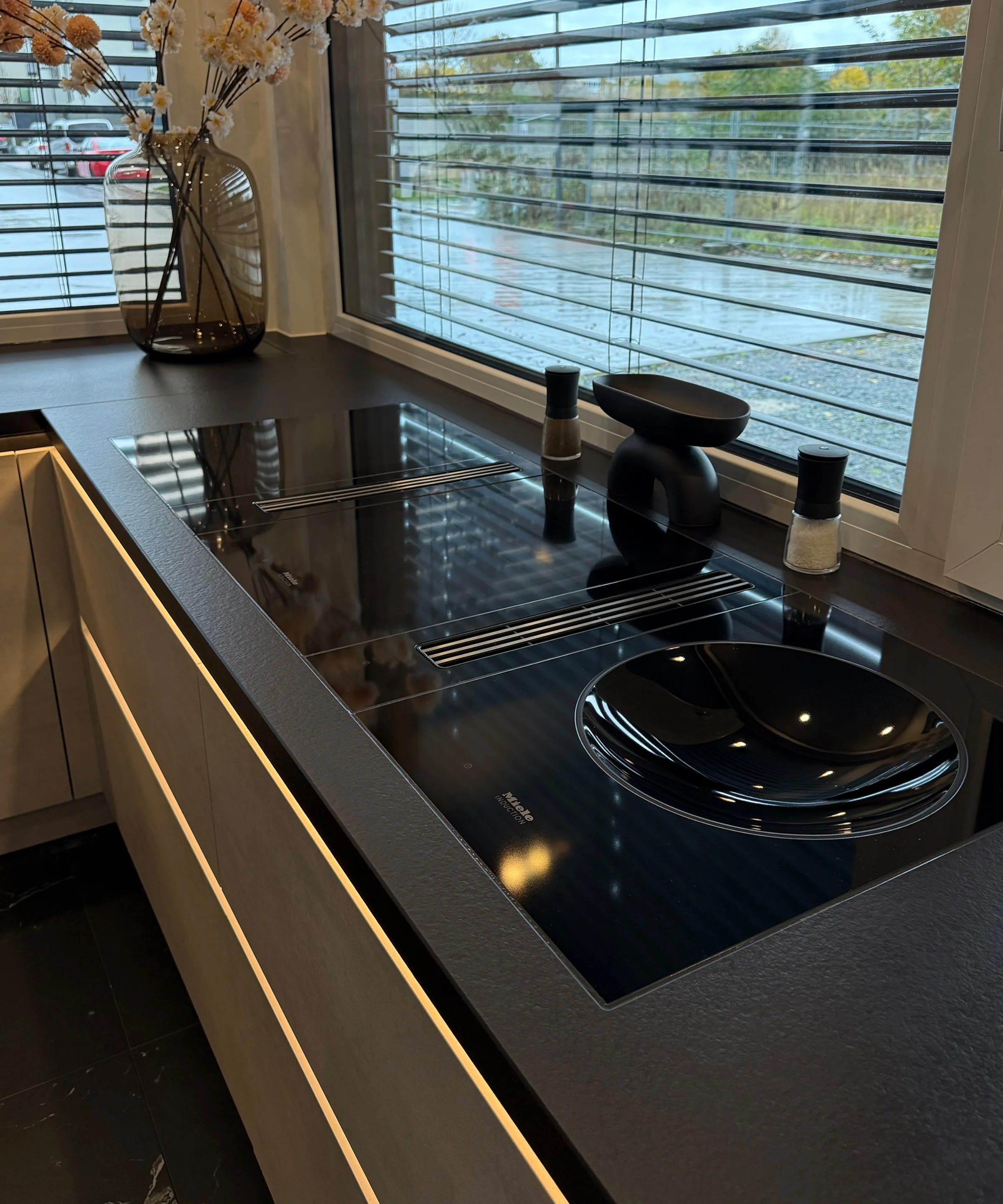 Una cucina moderna con piano cottura e vaso decorativo. Nolte Küchen.