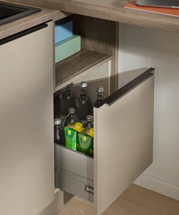 Un placard de cuisine ouvert montre des bouteilles et des caisses de boissons, partie de Nolte Kitchen.
