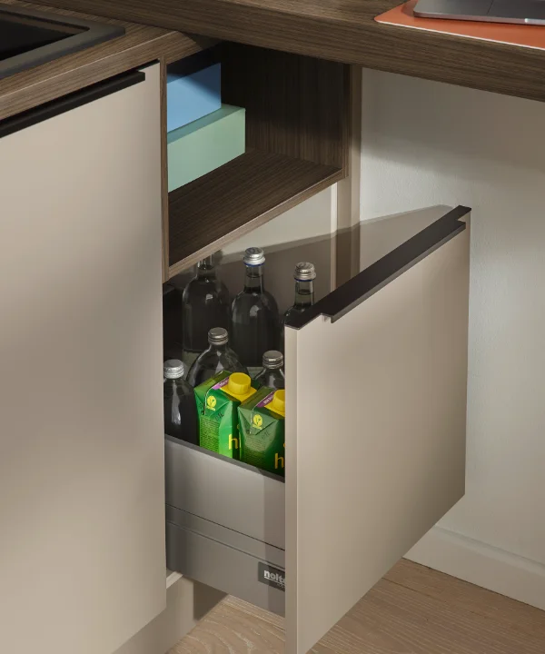 Ein geöffneter Küchenschrank zeigt Flaschen und Getränkekisten, Teil von Nolte Küchen.