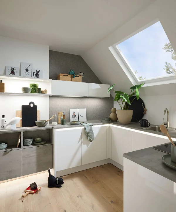 Eine moderne Küche mit weißen Schränken und Dachfenster, gestaltet von Nolte Küchen.