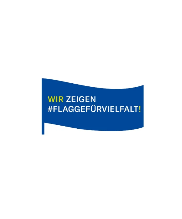 Eine blaue Fahne mit der Aufschrift "Wir zeigen #FlaggefürVielfalt!" weht im Wind.