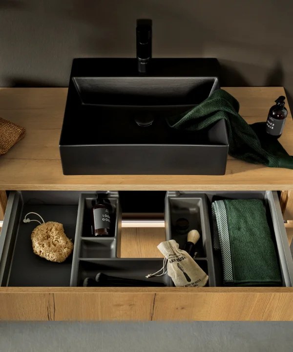 Ein modernes Badezimmer mit Holzschrank und schwarzen Waschbecken, Nolte SPA.