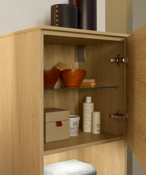 Ein geöffneter Badezimmerschrank mit Pflegeprodukten und Handtüchern, Nolte SPA.