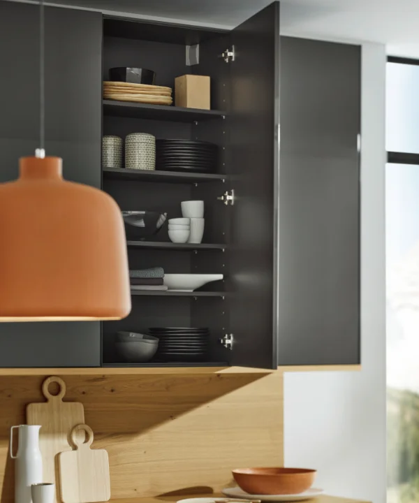 Eine moderne Küche mit geöffnetem Schrank zeigt Geschirr und Holzaccessoires, Nolte Küchen.