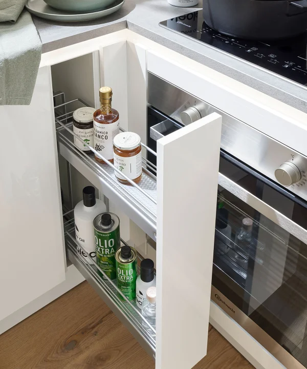 Ein offener Küchenunterschrank mit Gewürzen und Ölen, neben einem Herd. Nolte Küchen.